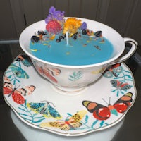 a blue teacup with butterflies and flowers on it