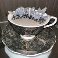 a tea cup and saucer with a candle in it
